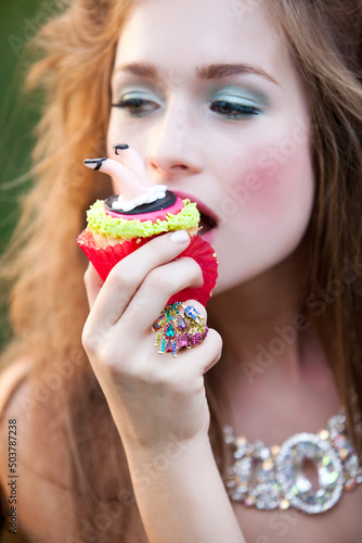 High Fashion Beauty Model with Makeup wearing Jewelry Holding Whimsical Alice in Wonderland Inspired Cake