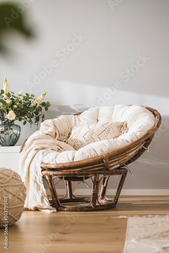 Rattan papasan chair with a beige pillow in a modern luminous apartment  photo