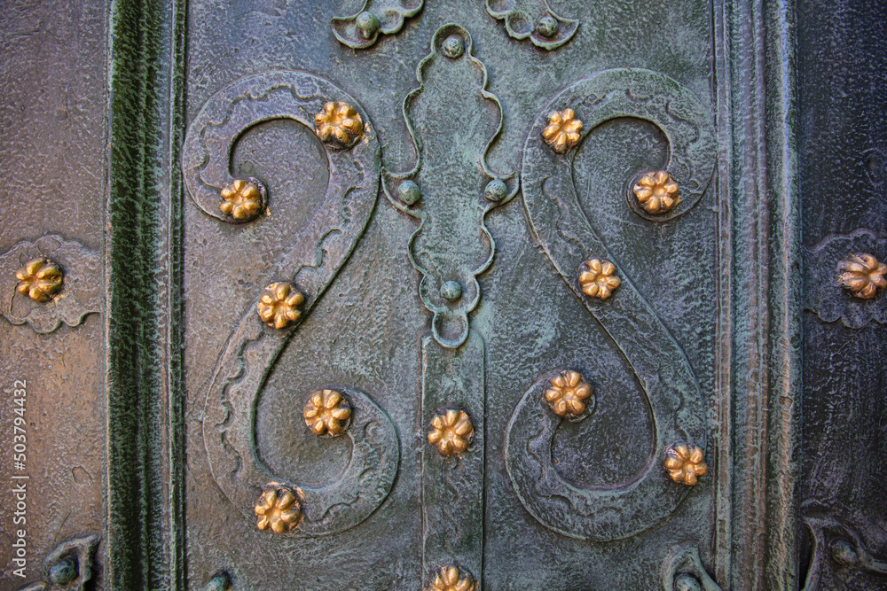Closeup of acient green forged doors with golden stars, tectured background. Dominican church in Lviv Closeup of acient green forged doors with golden stars, tectured background. Dominican church in Lviv