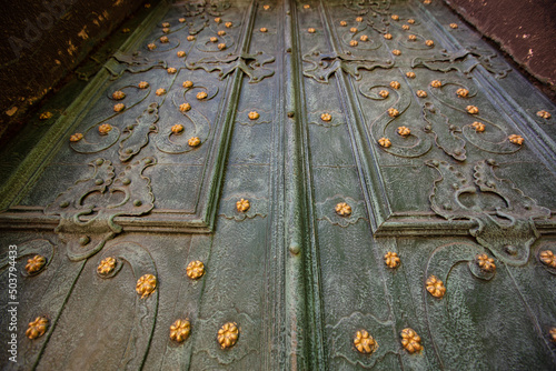 Closeup of acient green forged doors with golden stars, tectured background. Dominican church in Lviv photo