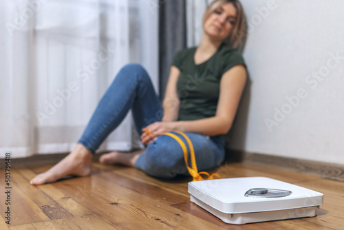 Cuadro en lienzo White scale and depression, upset and sad woman with measuring tape on wooden fl