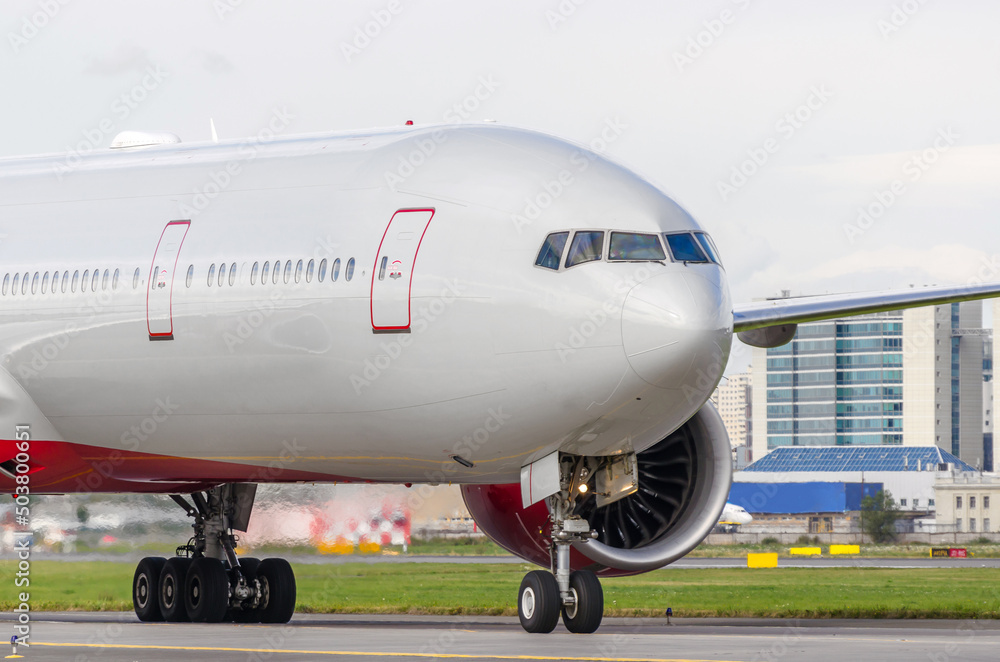 Passenger aircraft on the airport runway, against the backdrop of modern buildings city. Passenger aircraft on the airport runway, against the backdrop of modern buildings city.