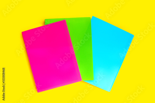 Office folders on yellow background. Top view