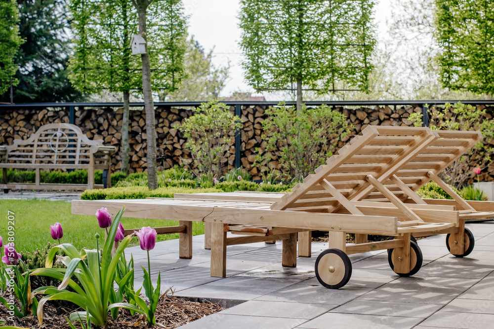 Fototapeta premium Leżaki ogrodowe na tarasie, strefa wypoczynku w nowoczesnym ogrodzie