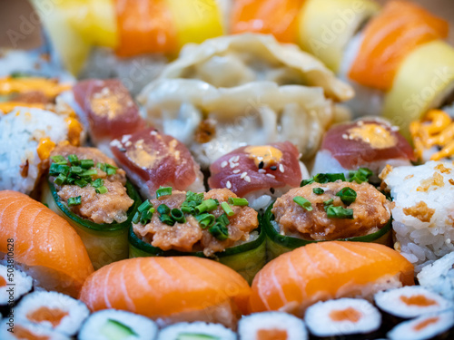 Sushi with salmon, rice, vegetable, mango and tuna. Arrangement of different sushi on a plate. Healthy sea food. 