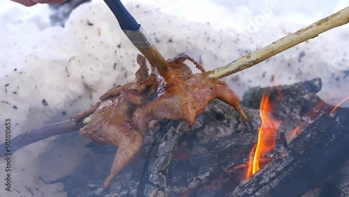 Wallpaper Mural Exotic process of cooking quail on an open fire in winter. Man greases quail meat with honey sauce with a brush. Concept: bushcraft, winter tourism. Torontodigital.ca