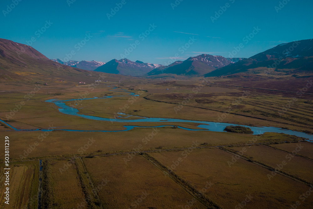 Fototapeta premium Beautiful valley of Miklavatn lake close to Haganes with aerial drone view of river delta and beautiful Icelandic hills and mountains in the background.