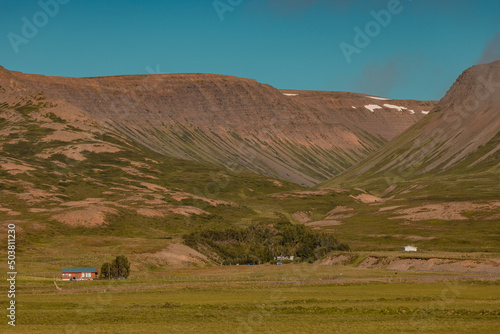 Valley close to Haganes ICeland with crystal clear blue water and some hills and country farms in the background. photo