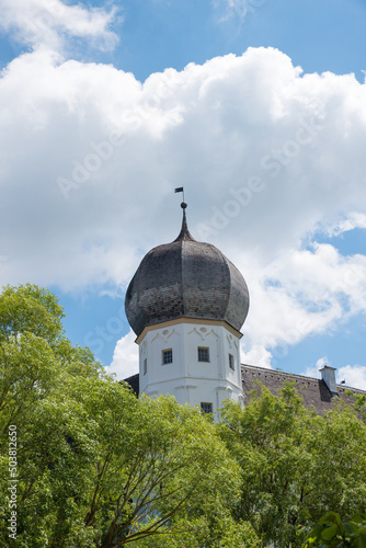 tower of historic moated castle Schwindegg, blue sky with clouds photo