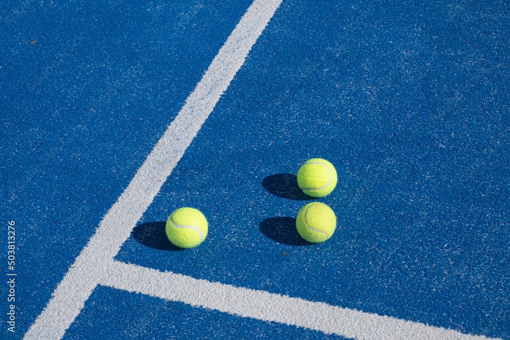 Selective focus, three balls on a paddle tennis court