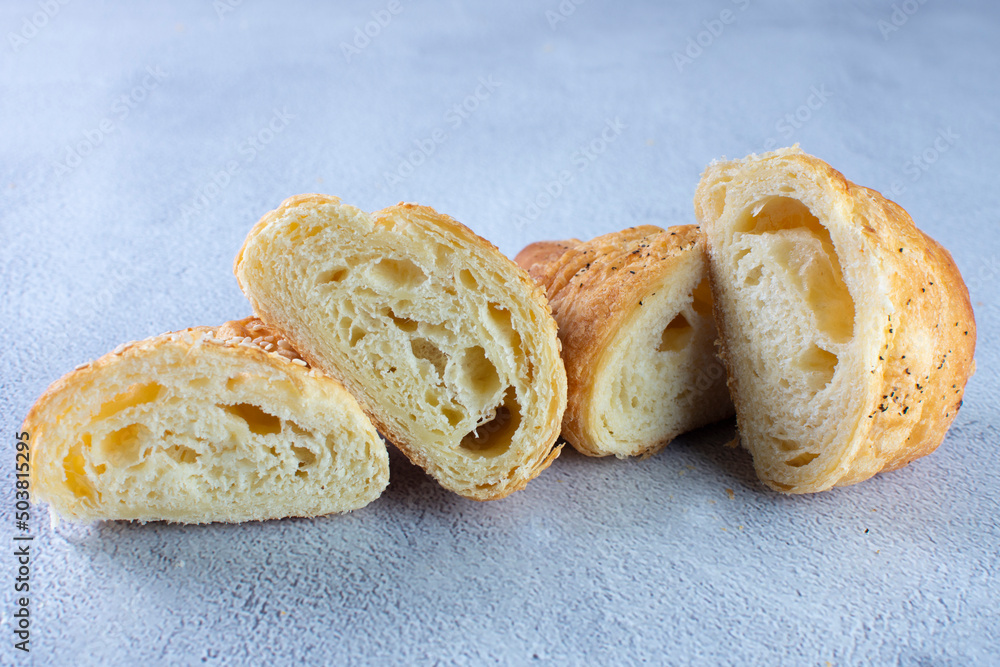 Gourmet cheese and sesame croissant, displayed on gray background Gourmet cheese and sesame croissant, displayed on gray background