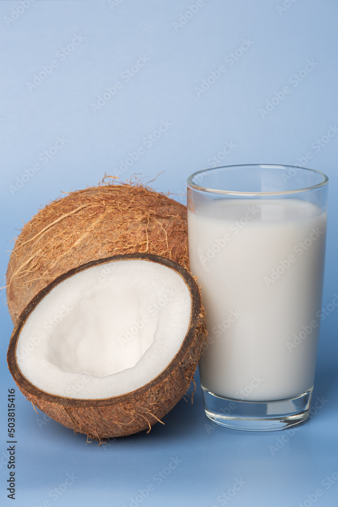 Glass of coconut milk with coconut on blue background Glass of coconut milk with coconut on blue background