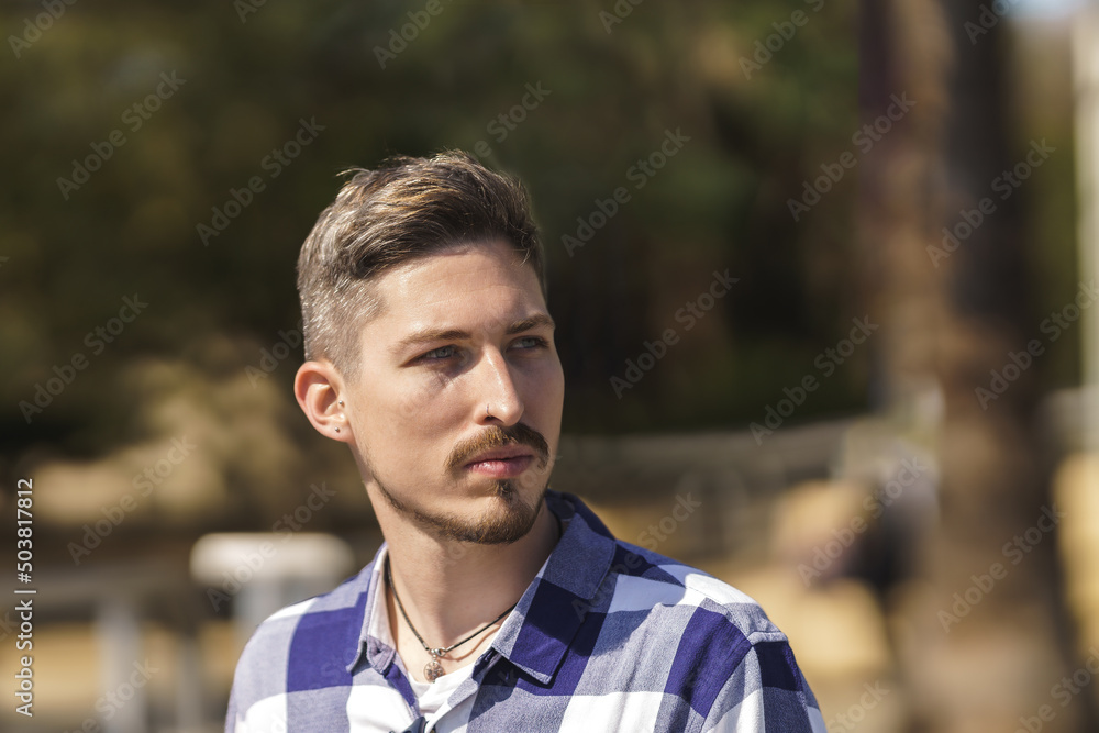 young man in blue plaid shirt looking to his left young man in blue plaid shirt looking to his left
