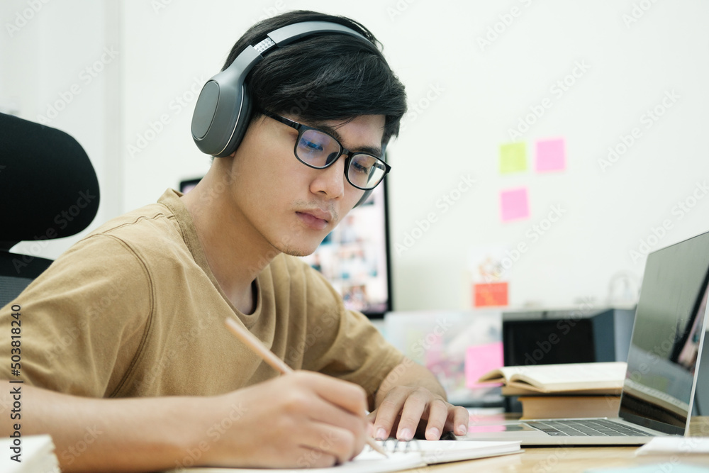 Young collage student using computer and mobile device studying Young collage student using computer and mobile device studying