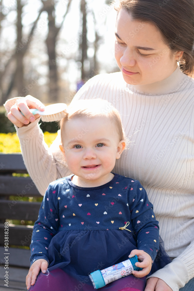 mother is combing daughter’s hair mother is combing daughter’s hair