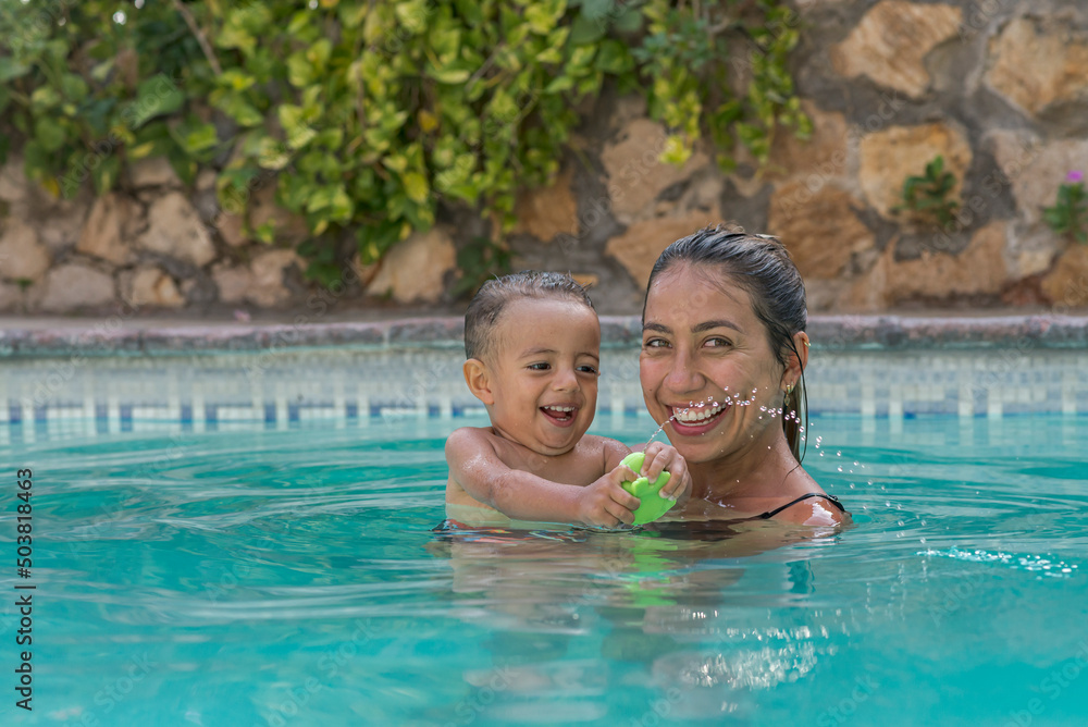 Latin baby boy and his mother having a good time at the pool