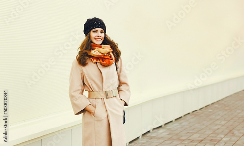 фотографія Portrait of beautiful young woman wearing coat and scarf in the city