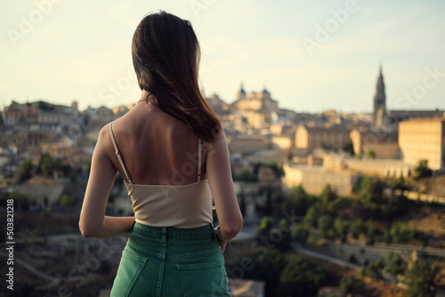 Fotografie, Obraz Rear view of a young woman enjoying the Toledo cityscape view from the observati