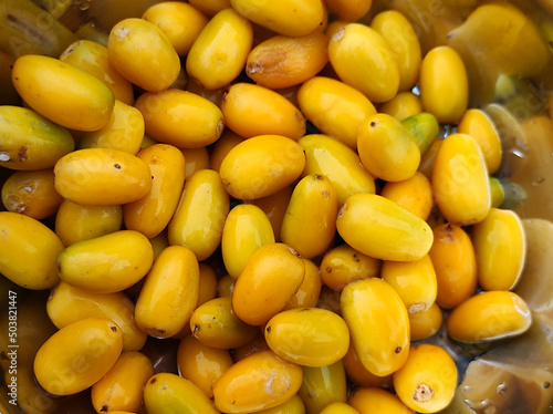 View of Manilkara Hexandra yellow fruits in a steel bowl photo