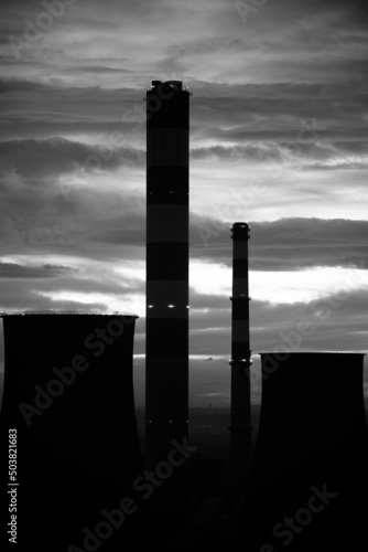 Vertical grayscale of tall chimneys of power plant photo