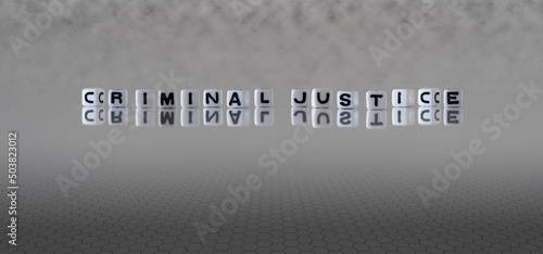 criminal justice word or concept represented by black and white letter cubes on a grey horizon background stretching to infinity