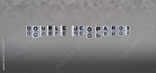 double jeopardy word or concept represented by black and white letter cubes on a grey horizon background stretching to infinity
