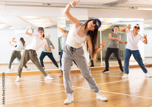 Teenagers boy and girls performing hip hop at group dance class