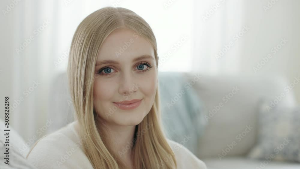 Beautiful blonde caucasian woman looks into camera in family room slow dolly Beautiful blonde caucasian woman looks into camera in family room slow dolly