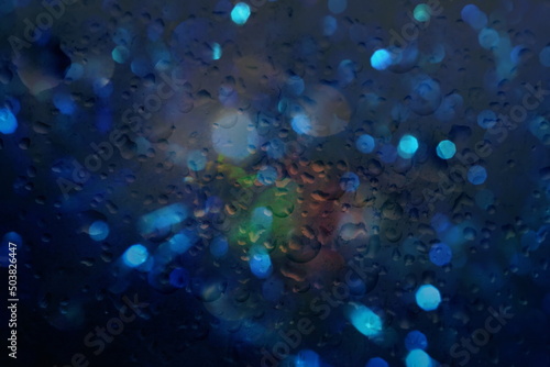  rain drops on window glass in night town rainy weather background blurred city light defocus
