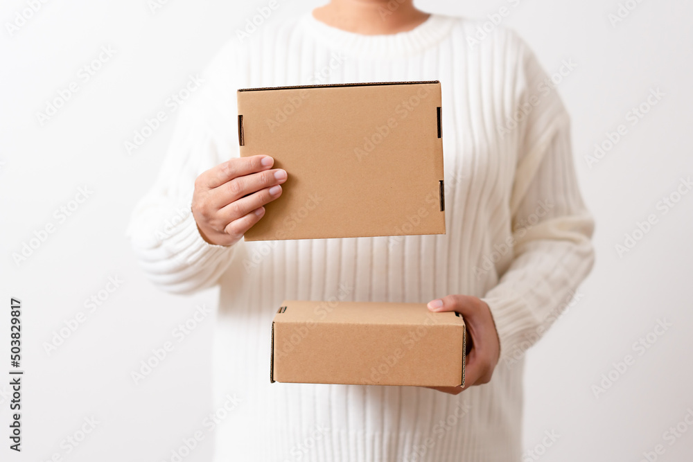 Woman hands holding present box with a ribbon bow. Concept of gift box minimalist style. Showing brown cardboard boxes delivery someone in special occasions or parcel deliver service. Woman hands holding present box with a ribbon bow. Concept of gift box minimalist style. Showing brown cardboard boxes delivery someone in special occasions or parcel deliver service.