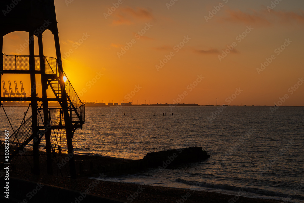 beach sunrise with seaside lighthouse beach sunrise with seaside lighthouse