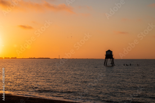 beach sunrise with seaside lighthouse