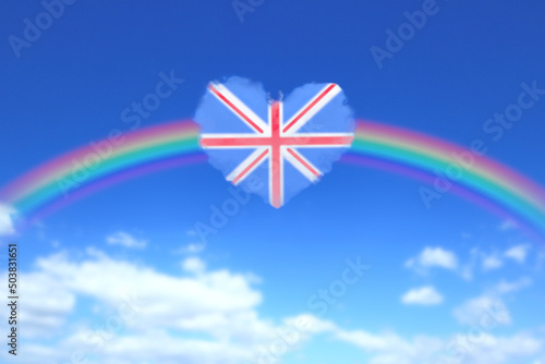 大きな虹とイギリスの国旗のようなハート形の雲が浮かぶ青空