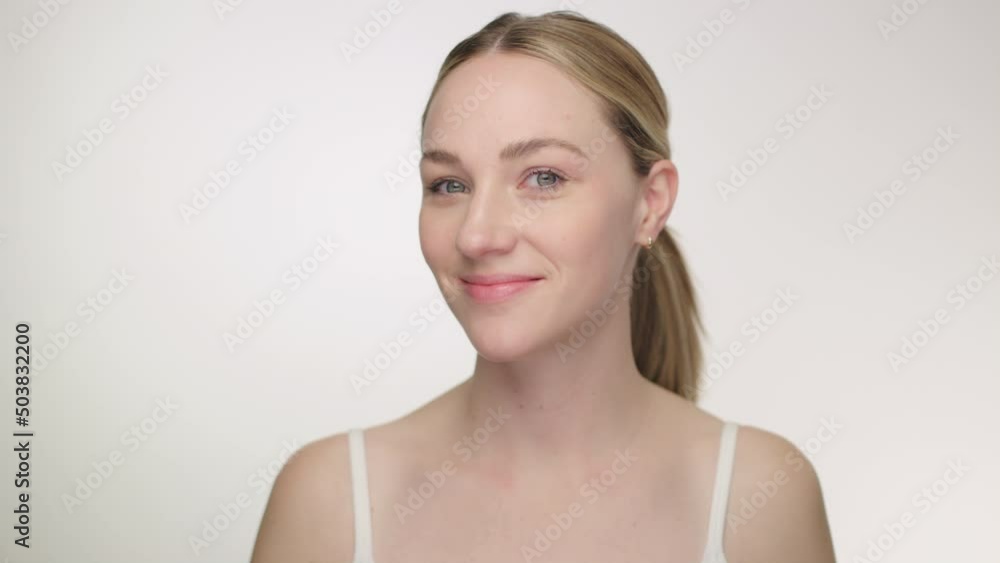 Beautiful blonde model looks into camera as she admires her appearance in mirror Beautiful blonde model looks into camera as she admires her appearance in mirror