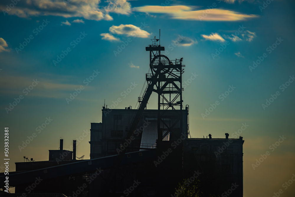 Coal mine on the background of light clouds in the sunset