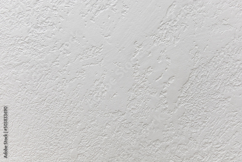 Rough wall decoration with white plaster, as a variant of modern interior decoration. Rough white wall. Texture or background for design