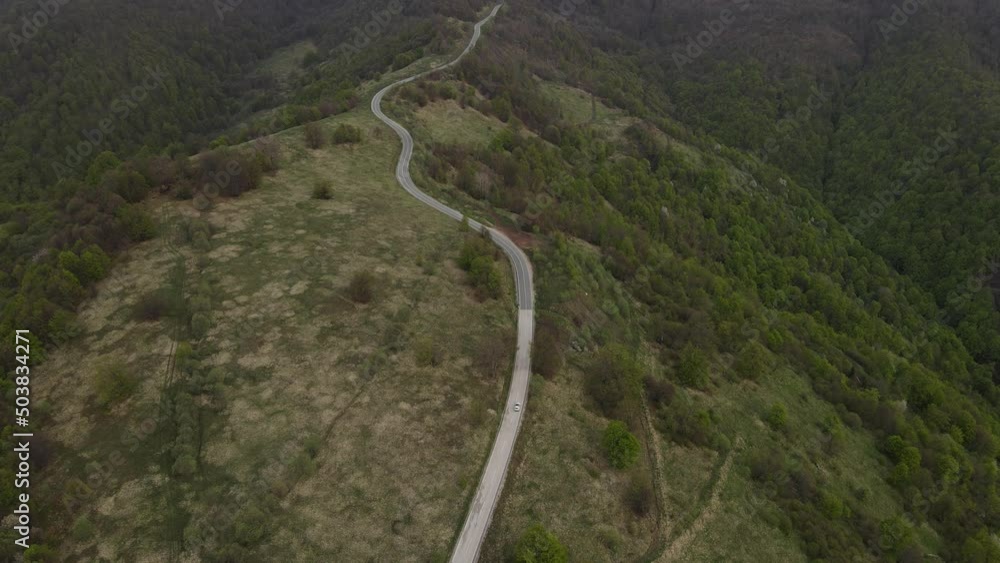 Top view on the road drone follow car while drive travel and tourism transportation concept in autumn or winter day trough the fields and trees on the old mountain stara planina near Knjazevac Serbia Top view on the road drone follow car while drive travel and tourism transportation concept in autumn or winter day trough the fields and trees on the old mountain stara planina near Knjazevac Serbia