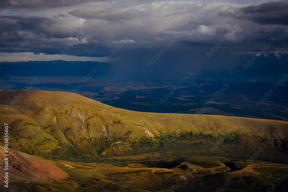 Downpour in the mountains. Heavy thunderclouds over picturesque hills and valleys. Beautiful natural background. Downpour in the mountains. Heavy thunderclouds over picturesque hills and valleys. Beautiful natural background.