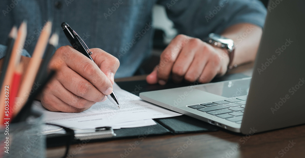 Close-up of man hand using writing pen memo on notebook paper or letter, diary on table desk office. Workplace for student, writer with copy space. business working and learning education concept. - obrazy, fototapety, plakaty 