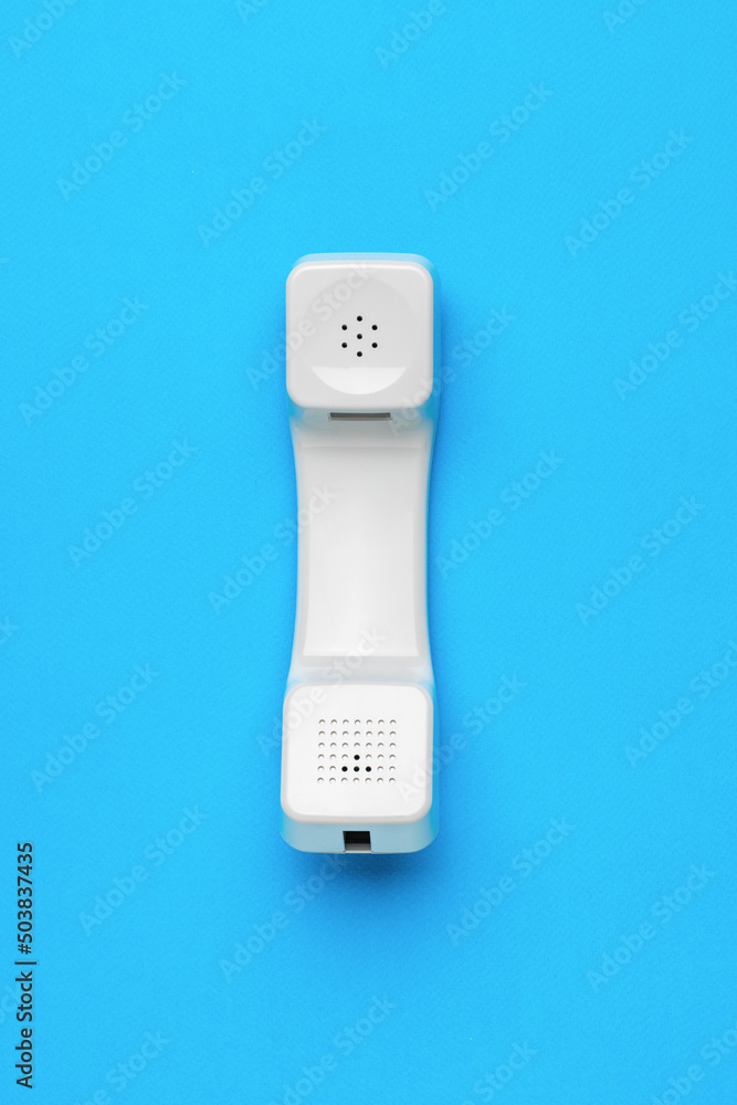White retro handset on a blue background. Minimal concept of communication organization.