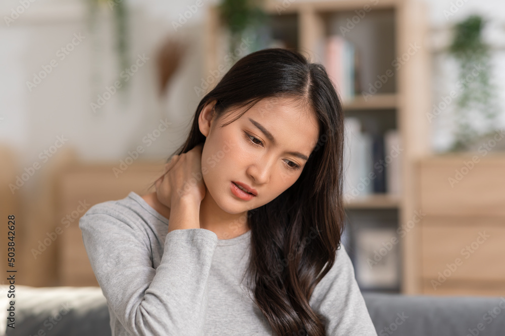 Fototapeta premium An Asian woman do self massage at her neck and shoulders. She has got back and pain on her muscles. Massage could help her release her pain but the best way is to asking the advices from the doctor.