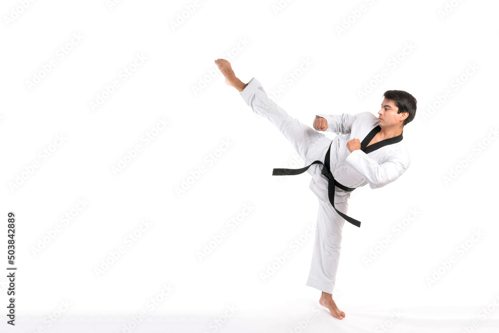 Taekwondo high kick - black belt taekwondo athlete martial arts master , handsome man show high kick pose during fighter training isolated on white background Taekwondo high kick - black belt taekwondo athlete martial arts master , handsome man show high kick pose during fighter training isolated on white background