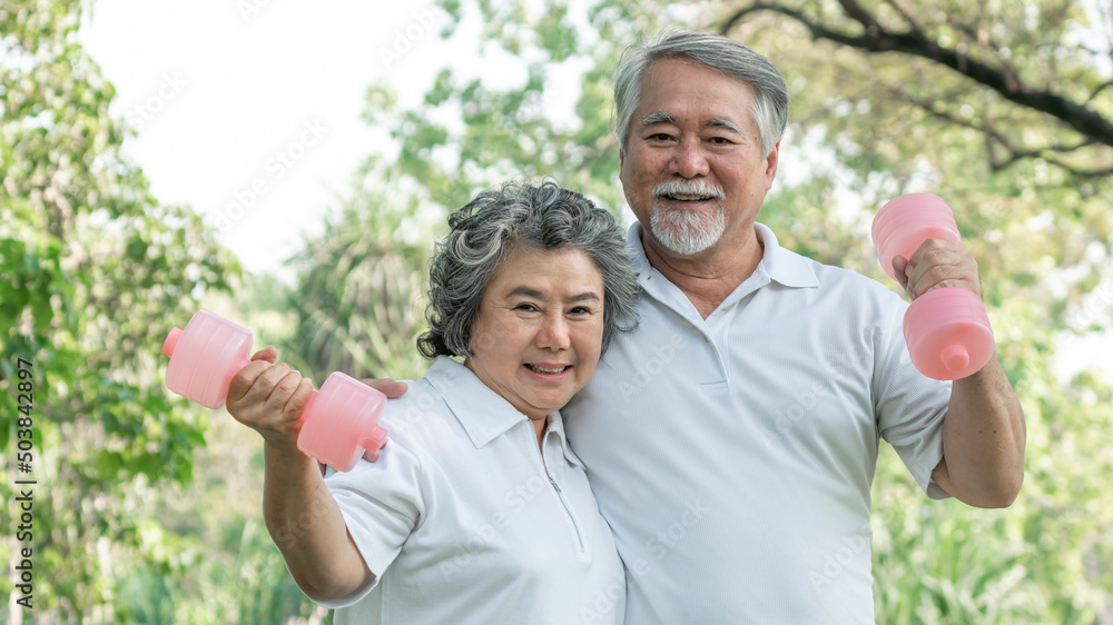 Cheerful elderly man and senior woman with dumbbell for workout in park, They smiling with good healthy together Cheerful elderly man and senior woman with dumbbell for workout in park, They smiling with good healthy together