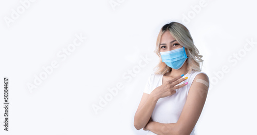 Portrait of Asian female wearing mask and holding three fingers for the third dose of vaccine on white background with copy space. © amenic181