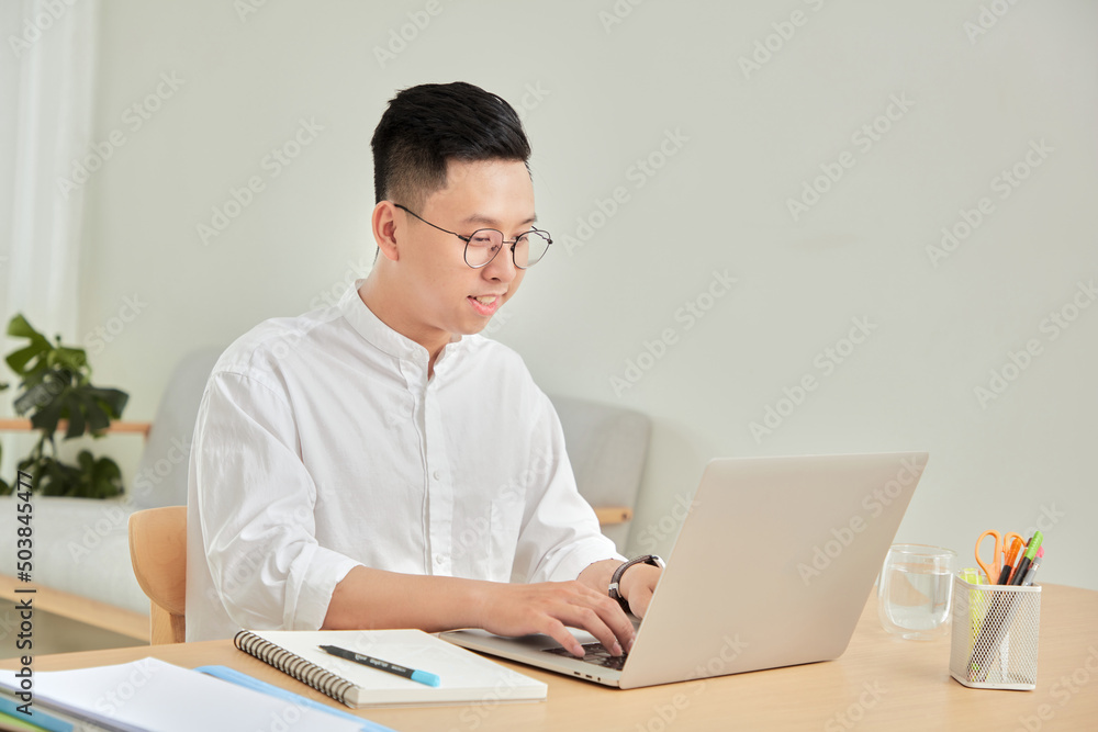 A moment of young working with laptop at home in living room background A moment of young working with laptop at home in living room background