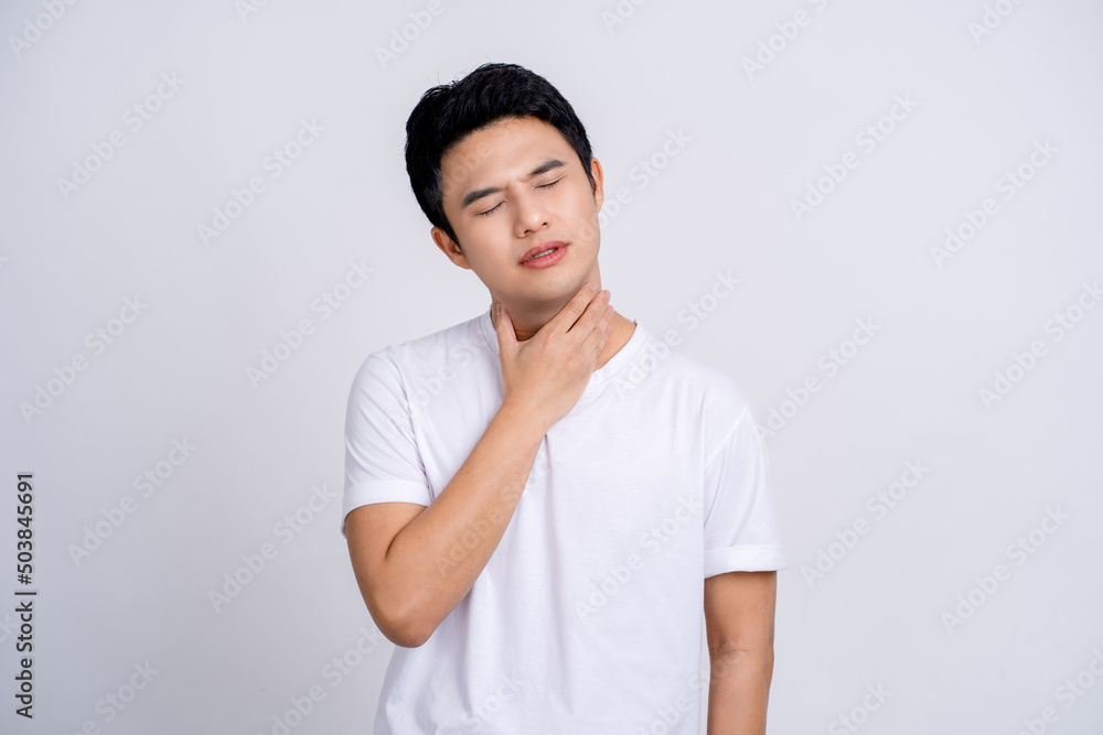 Portrait of young asian man in casual white t-shirt isolated on white background. He had a sore throat and touched his throat. Difficult to swallow. Portrait of young asian man in casual white t-shirt isolated on white background. He had a sore throat and touched his throat. Difficult to swallow.