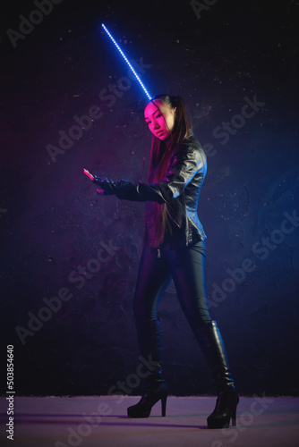 Concept of futuristic woman soldier with the katana sword in the neon lights.