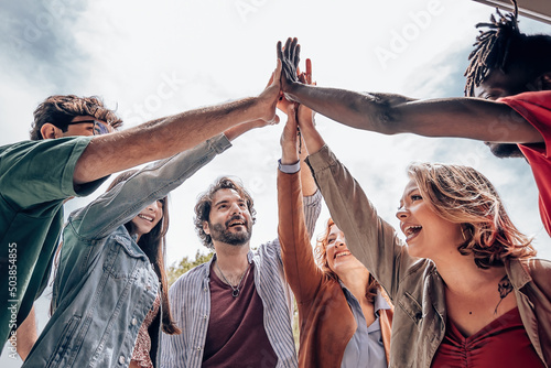 Foto young people giving high five - group of diverse multiethnic people make unity - collaboration team success concept