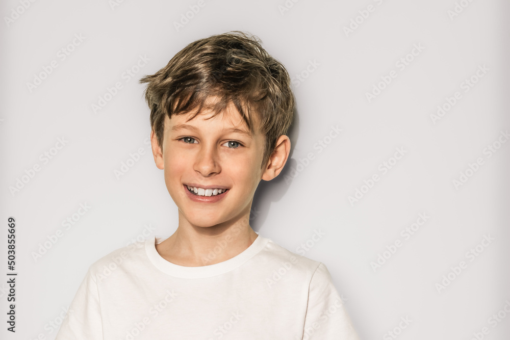 Portrait of a handsome smiling 9 year old white caucasian boy in a white t-shirt on a white background with copy space Portrait of a handsome smiling 9 year old white caucasian boy in a white t-shirt on a white background with copy space