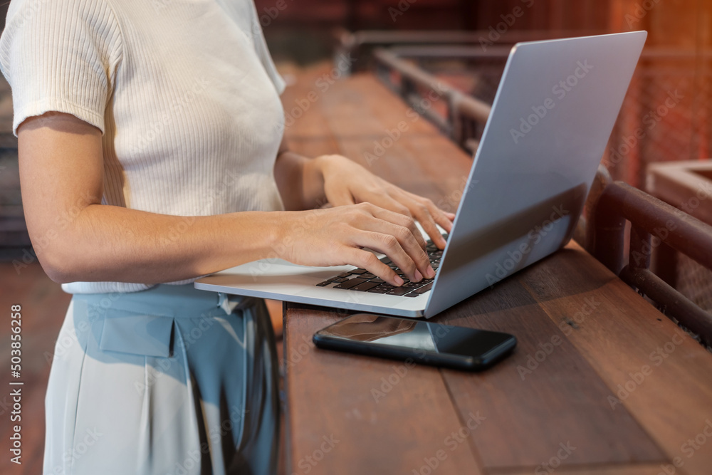 Naklejka premium Casual Businesswoman using laptop, freelance woman typing keyboard computer notebook in cafe or modern office. technology, digital online and network concept